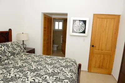 a bedroom with a bed and a door to a bathroom at 2BR 2BA Beachfront With View 62 in Bayahibe
