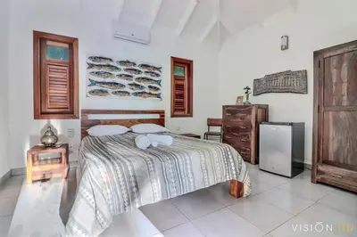 a bedroom with a bed and a refrigerator at Casa Zebra lovely villa near the beach in Las Terrenas