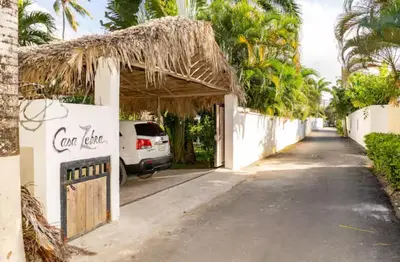 a street with a building with a thatch roof at Casa Zebra lovely villa near the beach in Las Terrenas