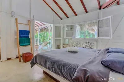 a bedroom with a large bed in a room with windows at Casa Zebra lovely villa near the beach in Las Terrenas