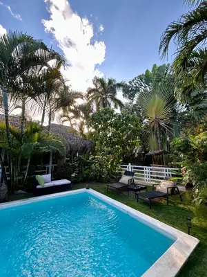 a swimming pool in a yard with palm trees at Casa Zebra lovely villa near the beach in Las Terrenas