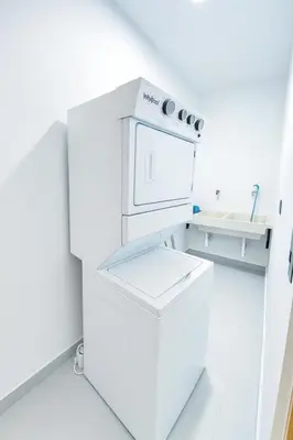 a white kitchen with a stove and a sink at 2-bedroom apartment with 24h electricity and private parking in Sosúa