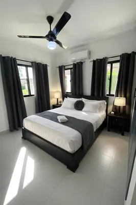 a bedroom with a large bed with a ceiling fan at 2-bedroom apartment with 24h electricity and private parking in Sosúa