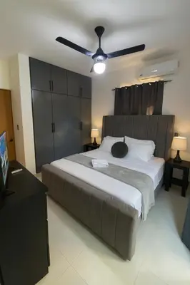 a bedroom with a large bed with a ceiling fan at 2-bedroom apartment with 24h electricity and private parking in Sosúa