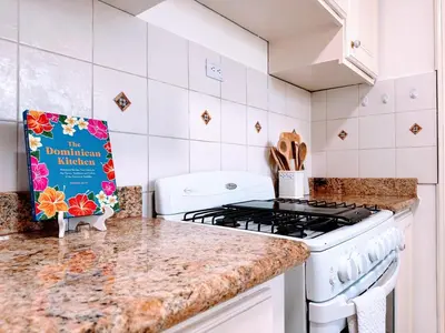 a kitchen with a stove and a book on the counter at Backyard, Pool View, Walk to Beach, Dining, Shops in Punta Cana