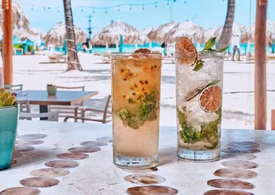 two cocktails sitting on a table at the beach at Backyard, Pool View, Walk to Beach, Dining, Shops in Punta Cana