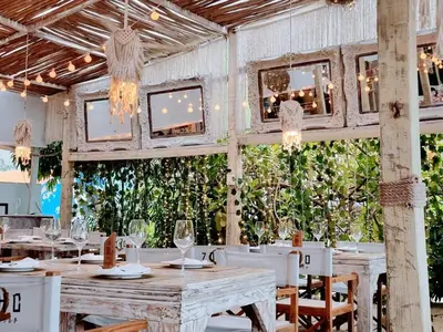 a restaurant with white tables and chairs and plants at Backyard, Pool View, Walk to Beach, Dining, Shops in Punta Cana