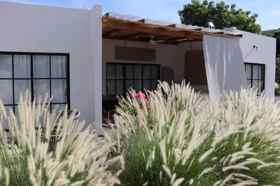 a white house with plants in front of it at no available in Hatillo