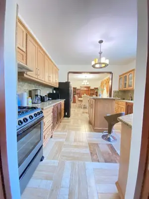 a kitchen with wooden cabinets and a stove at Beautiful Villa with Mountain view in San Felipe de Puerto Plata