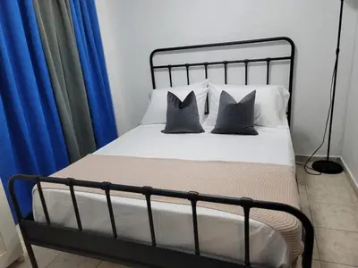 a bed with two pillows on it with blue curtains at Fantastic apartment 1Rooms zona colonial in Santo Domingo