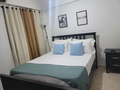 a bedroom with a bed with blue and white pillows at Fantastic apartment 1Rooms zona colonial in Santo Domingo