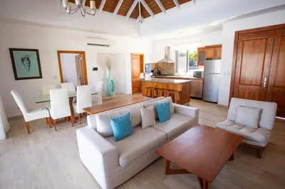 a living room with a couch and a table and a kitchen at Santa Fe Club in Sosúa