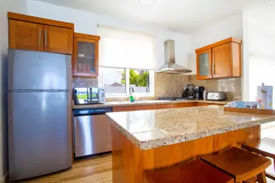 a kitchen with a stainless steel refrigerator and wooden cabinets at Santa Fe Club in Sosúa
