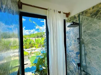a bathroom with a window with a view of the ocean at Casa Ola, luxurious jungle house in El Valle