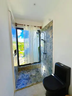 a bathroom with a shower with a toilet and a window at Casa Ola, luxurious jungle house in El Valle