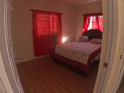 a bedroom with a bed and red curtains at Hotel Mi Propio Esfuerzo in Vicente Noble