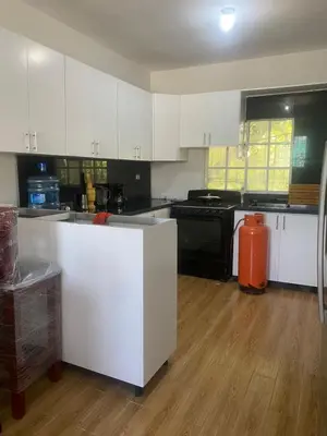 a kitchen with white cabinets and black appliances at Hotel Mi Propio Esfuerzo in Vicente Noble