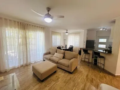 a living room with a couch and a table at Paradise Arenas De Bávaro RD in Punta Cana