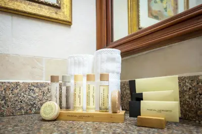 a bathroom counter with some bottles of soap and a mirror at Hodelpa Garden Suites - All Inclusive in Juan Dolio
