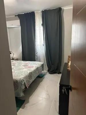 a bedroom with a bed and a window with curtains at Ester house Sabaneta in Sabaneta