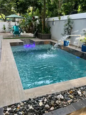 a swimming pool with a waterfall in a backyard at Casa en río san Juan 4 habitaciones in Río San Juan