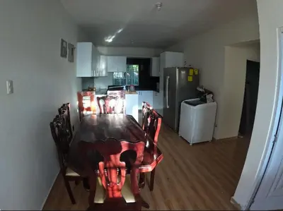 a kitchen with a table and chairs and a refrigerator at My propio esfuerzo in Vicente Noble