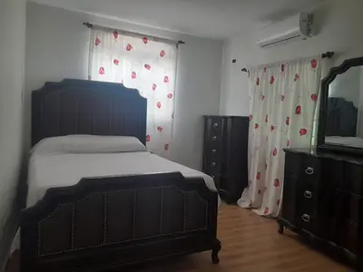 a bedroom with a bed and a dresser and a mirror at My propio esfuerzo in Vicente Noble