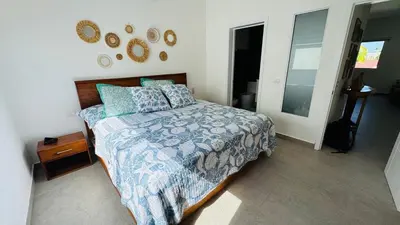 a bedroom with a bed with a blue blanket and pillows at Punta Popy Beach Apartment in Las Terrenas