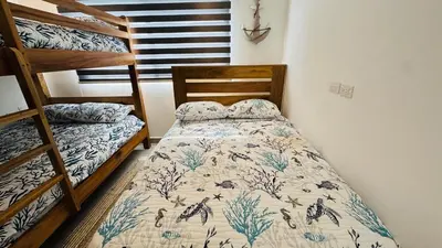 a bedroom with a bed and a bunk bed at Punta Popy Beach Apartment in Las Terrenas