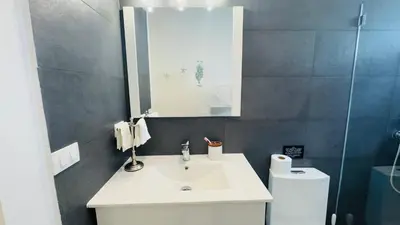 a bathroom with a sink and a mirror and a toilet at Punta Popy Beach Apartment in Las Terrenas