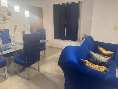 a living room with a blue couch and a table at Renta Vacacional en el Caribe in Ciruelitos Arriba