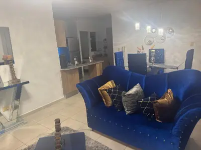 a blue couch with pillows in a living room at Renta Vacacional en el Caribe in Ciruelitos Arriba