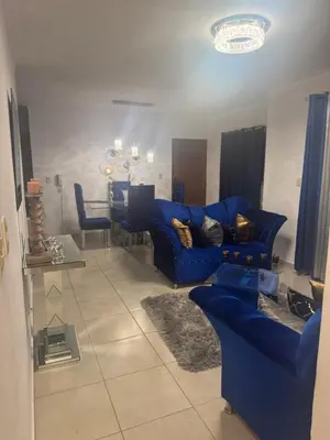 a living room with a blue couch and a table at Renta Vacacional en el Caribe in Ciruelitos Arriba