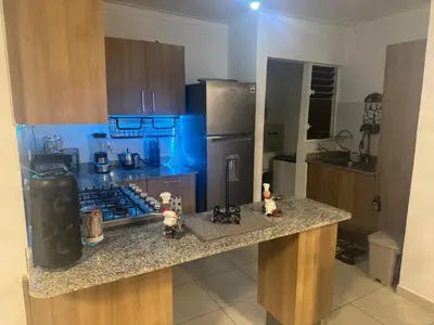 a kitchen with a counter and a refrigerator at Renta Vacacional en el Caribe in Ciruelitos Arriba