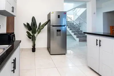 a stainless steel refrigerator in a kitchen with stairs at Beautiful ocean and mountain view villa in Gaspar Hernández
