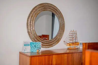 a mirror on top of a wooden dresser with a ship at Beautiful ocean and mountain view villa in Gaspar Hernández