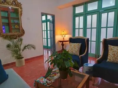 a living room with two chairs and a table at Colonial City Stay with Local Soul in Santo Domingo