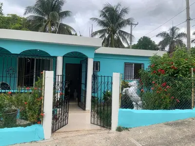 a blue house with a gate and flowers at Villa francia in Santa Cruz de Barahona