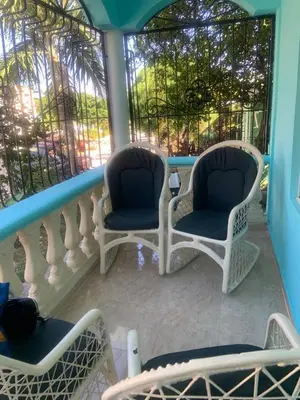 two chairs sitting on a balcony with a window at Villa francia in Santa Cruz de Barahona