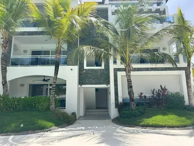 a building with palm trees in front of it at Caribbean Dream Condo AC WIFI in La Laguna