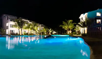 a large swimming pool with blue water at night at Caribbean Dream Condo AC WIFI in La Laguna