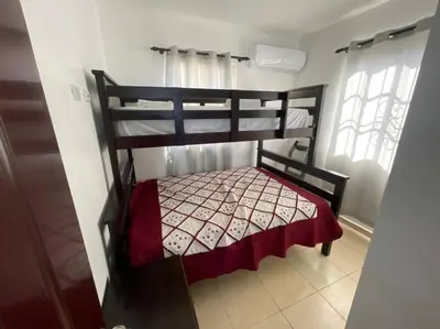 a bedroom with a bunk bed with a red blanket at Villas Hillside apt 2 in Santa Bárbara de Samaná