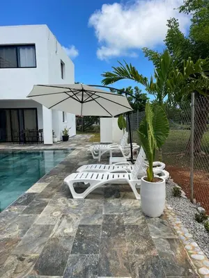 a pool with two lounge chairs and an umbrella at Casa Entre Playas - 14 pax, 3 min de la playa en Las Galeras in Las Galeras