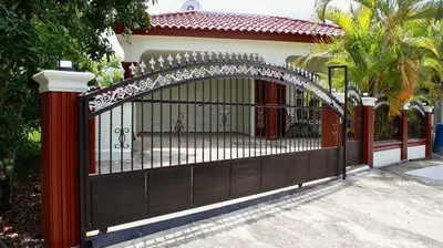 a black gate with an arch in front of a house at Casa de la presa in Monción