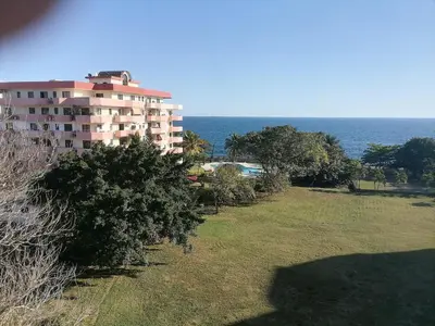 a large apartment building with trees and the ocean at Quiet apartment, good access to Supermarkets, Center etc in Santo Domingo