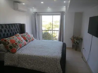 a bedroom with a bed and a large window at Quiet apartment, good access to Supermarkets, Center etc in Santo Domingo