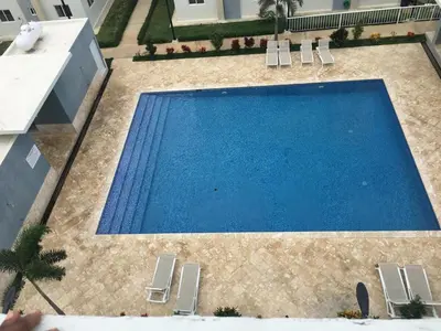an overhead view of a large blue swimming pool with chairs at Your Terrazas Del Este Getaway In La Romana in Cumayasa Kilómetros Diez