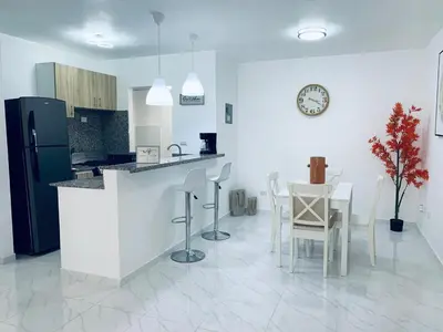 a kitchen with a counter and a table and chairs at Your Terrazas Del Este Getaway In La Romana in Cumayasa Kilómetros Diez