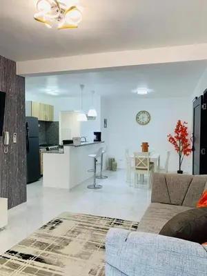 a living room and kitchen with a couch and a table at Your Terrazas Del Este Getaway In La Romana in Cumayasa Kilómetros Diez