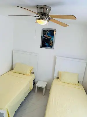 two beds in a room with a ceiling fan at Your Terrazas Del Este Getaway In La Romana in Cumayasa Kilómetros Diez